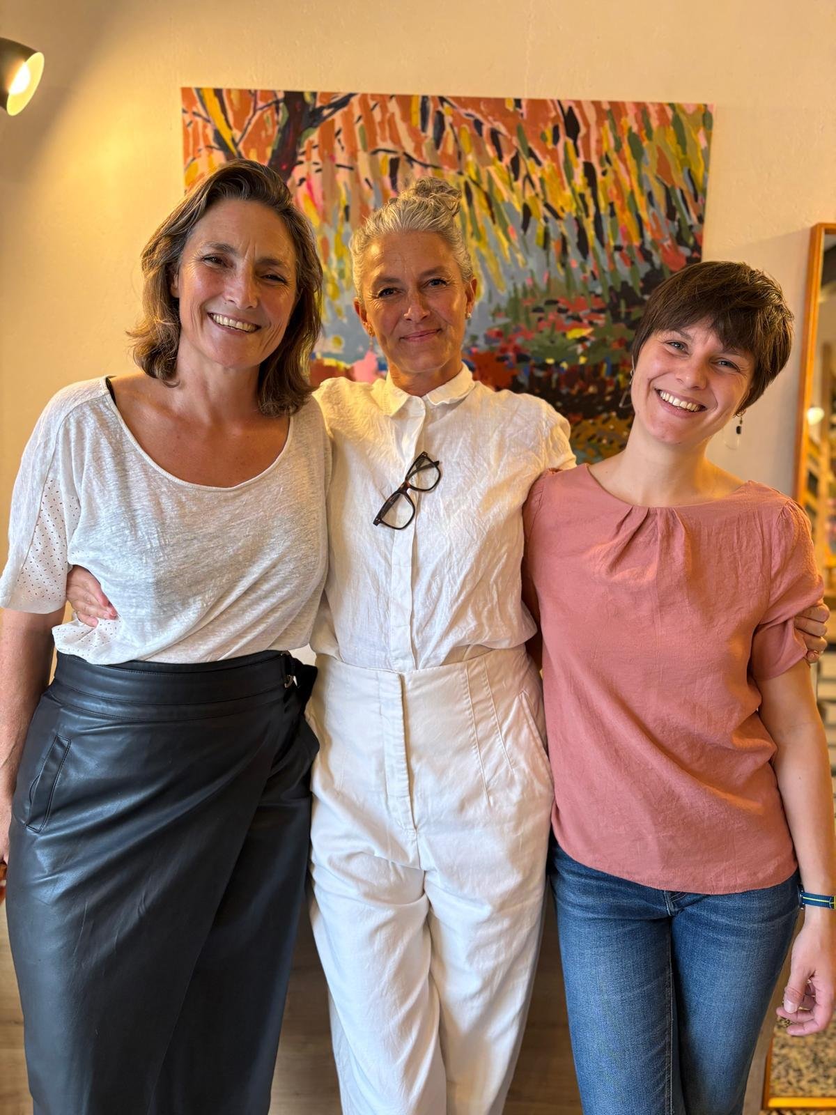 La peintre Cécile Carré avec Cécile et Suzon de l'Atelier Polychrome, devant une de ses toiles, au vernissage de Près du soleil